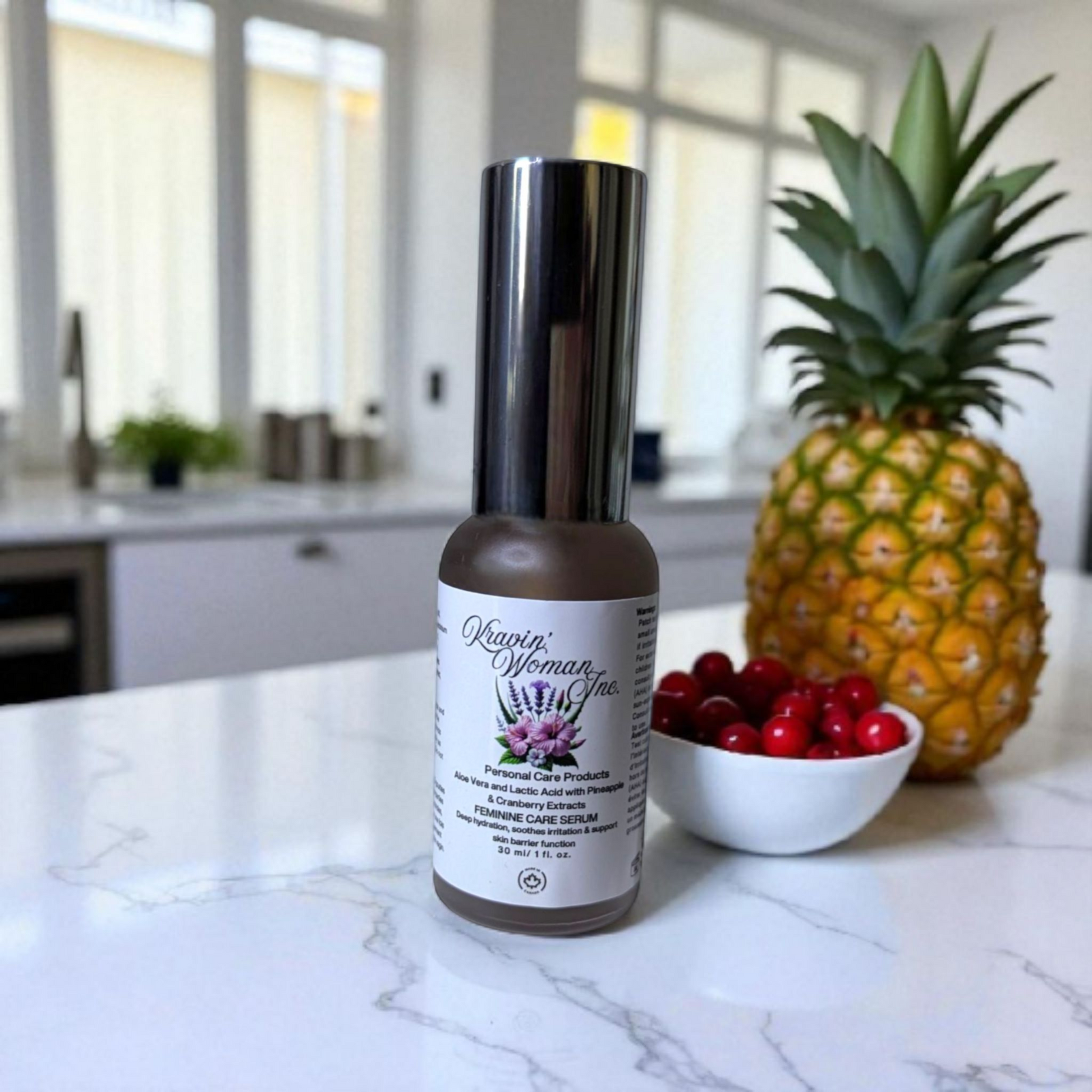 Bottle of Kravin woman frosted glass pump on a kitchen counter with a pineapple and bowl of berries.